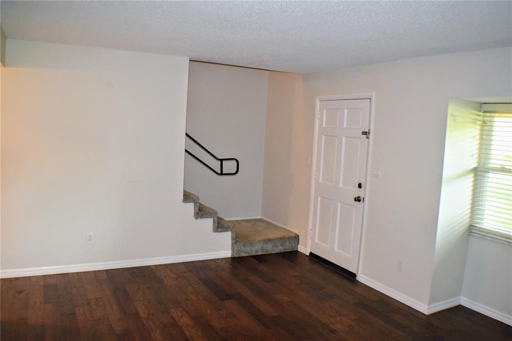 An interior room features dark wood flooring, white walls, a white door, and carpeted stairs — 814 PARK LAKE CIRCLE UNIT 8, MAITLAND, FL