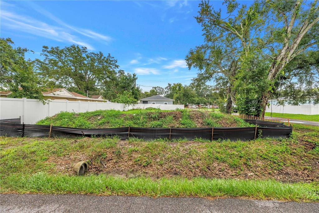 A vacant, elevated lot enclosed by a black silt fence and a white vinyl fence — 6401 29TH STREET N, ST PETERSBURG, FL