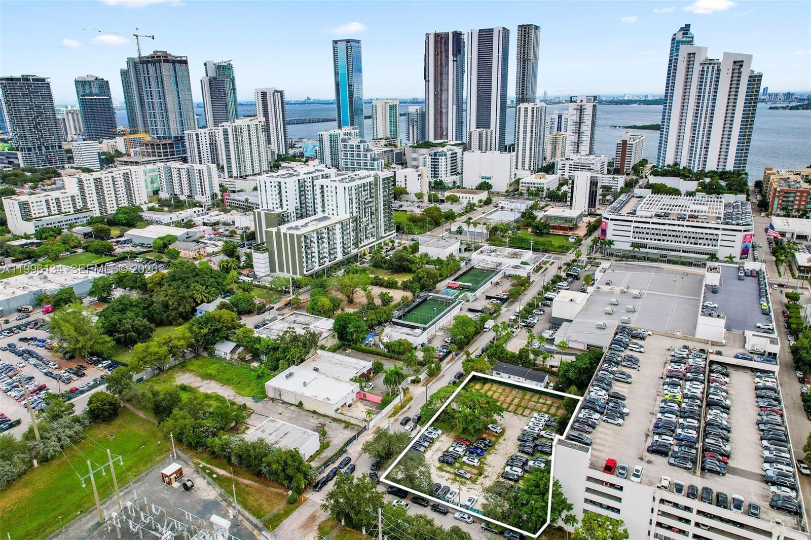 An aerial view shows a rectangular vacant lot surrounded by parking lots and city buildings — 100 NE 21st St, Miami FL 33137, MIAMI, FL