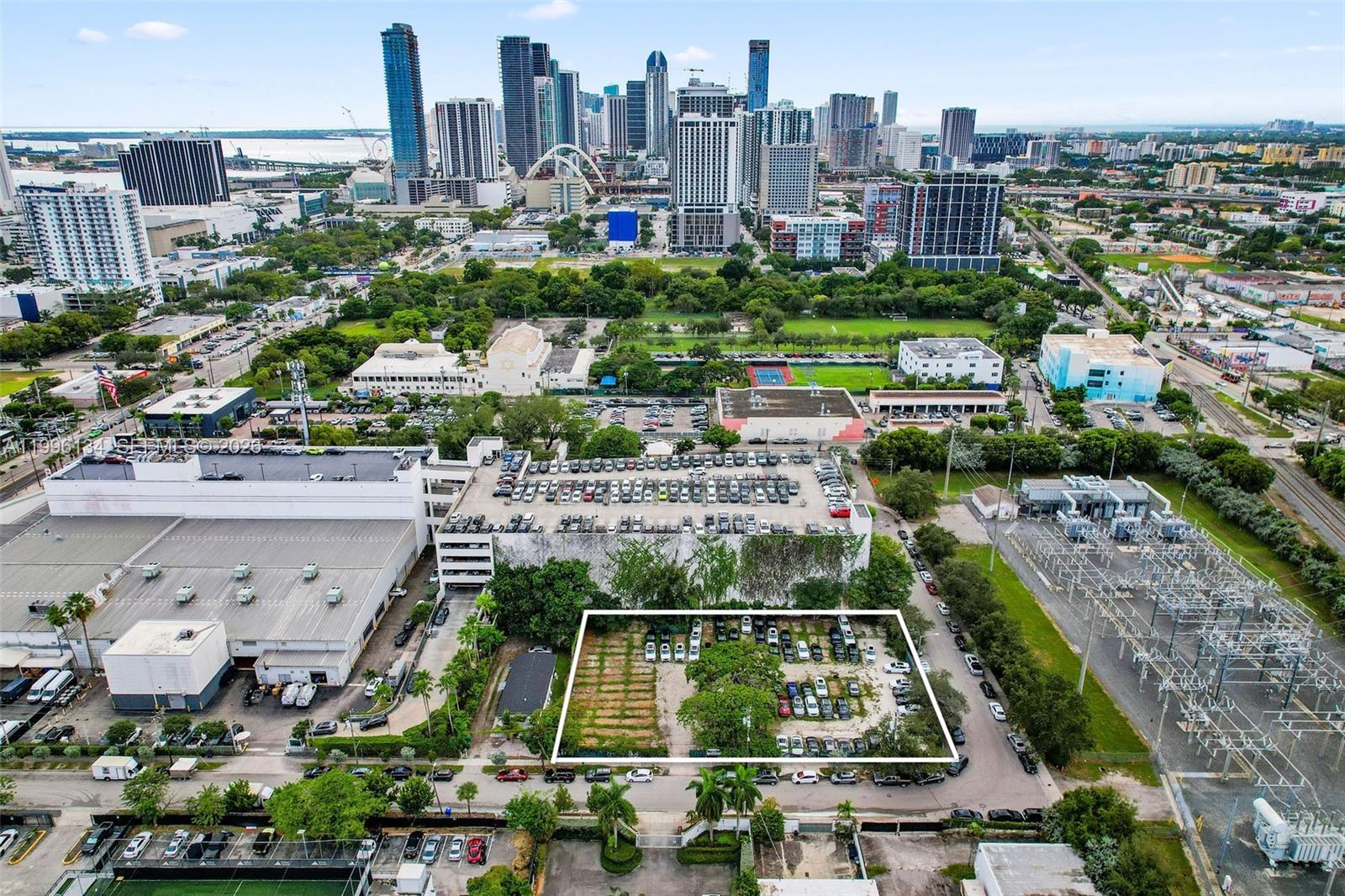 An aerial view shows a rectangular vacant lot surrounded by parking and urban infrastructure — 100 NE 21st St, Miami FL 33137, MIAMI, FL