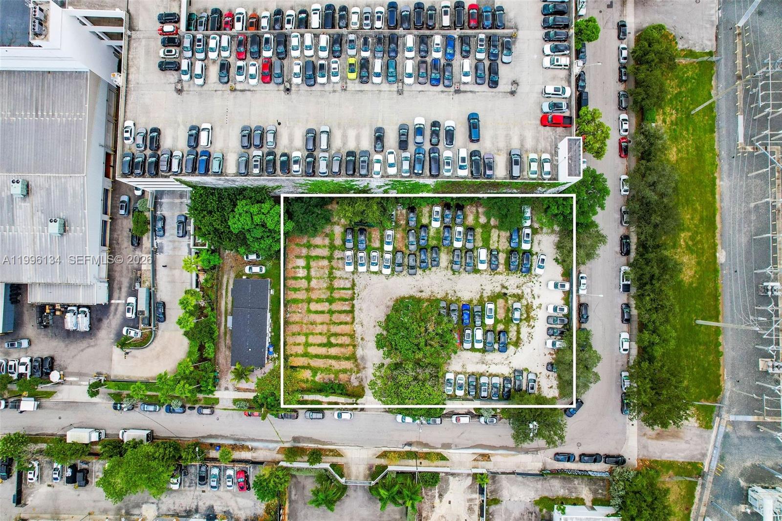 An aerial view shows a rectangular lot with parked cars and vegetation next to buildings — 100 NE 21st St, Miami FL 33137, MIAMI, FL
