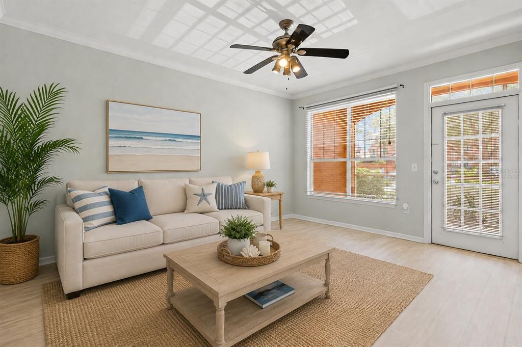 A living room features a beige sofa, a wooden coffee table, and a ceiling fan — 5000 CULBREATH KEY WAY UNIT 1-107, TAMPA, FL