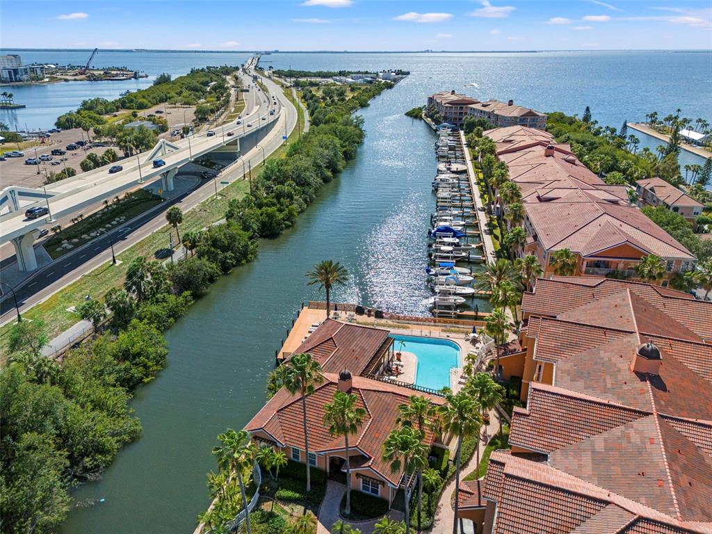 An aerial view shows a waterfront residential complex with a swimming pool and boat slips — 5000 CULBREATH KEY WAY UNIT 1-107, TAMPA, FL