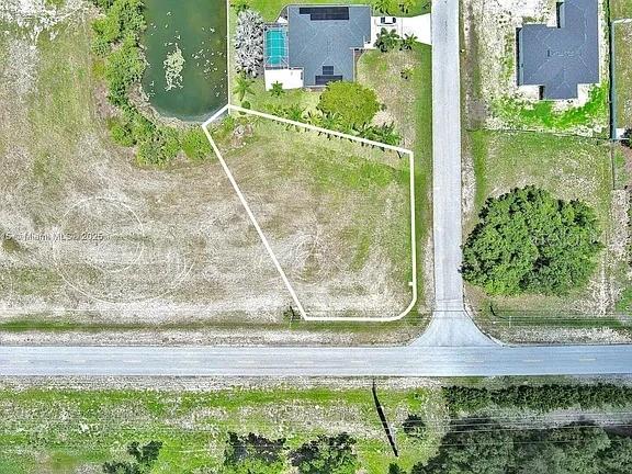 This aerial view shows a vacant, irregularly shaped residential lot outlined in white — 3417 ANDALUSIA BOULEVARD, CAPE CORAL, FL