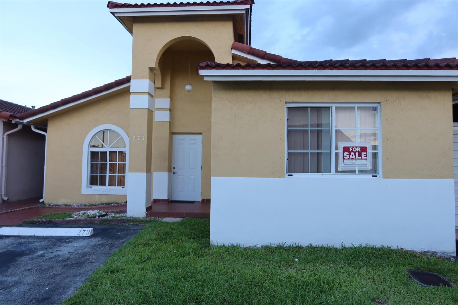 A single-story yellow house with a white base, arched window, and a for sale sign — 7001 W 35th Avenue # 273, Hialeah FL 33018, HIALEAH, FL