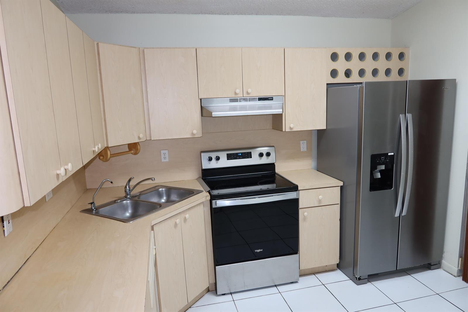 A kitchen features light wood cabinets, stainless steel appliances, a double sink, and white tile — 7001 W 35th Avenue # 273, Hialeah FL 33018, HIALEAH, FL