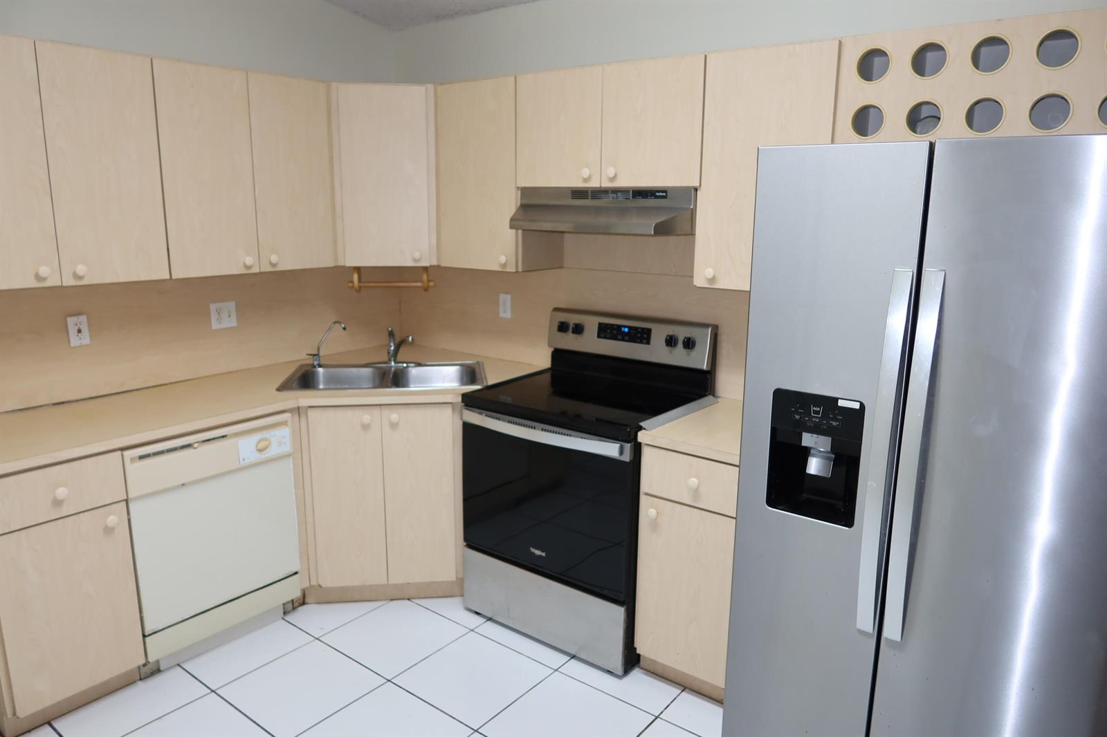 A kitchen features light wood cabinets, stainless steel appliances, and white tile flooring — 7001 W 35th Avenue # 273, Hialeah FL 33018, HIALEAH, FL