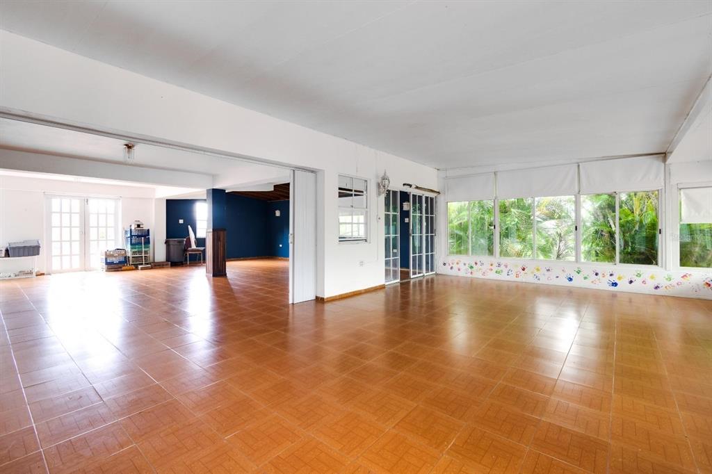 A large, open-concept room with brown tile flooring, white walls, and floor-to-ceiling windows — 734 BO ARENAS, CIDRA, PR