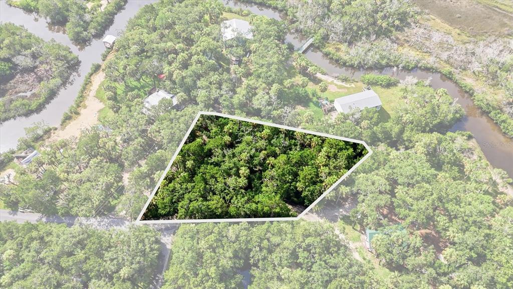 An aerial view shows a wooded, trapezoidal lot surrounded by trees and nearby waterways — 1114 S URCHIN POINT, CRYSTAL RIVER, FL