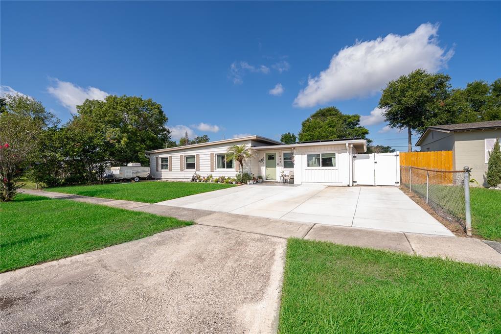 A single-story house with white siding, a concrete driveway, and a fenced side yard — 1624 HOLLIS DRIVE, ORLANDO, FL