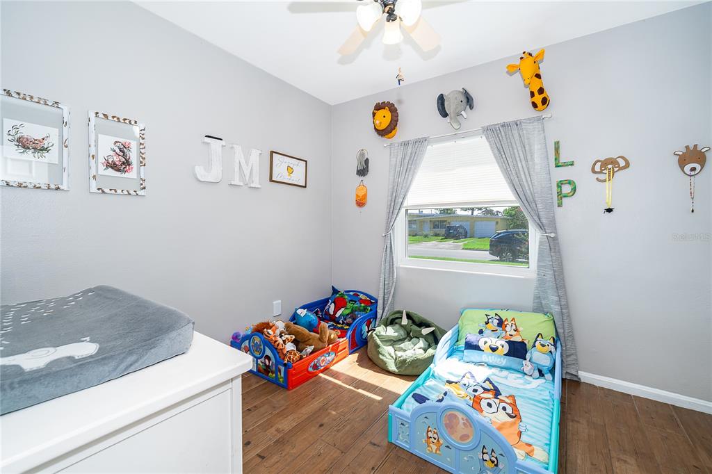 A child's bedroom features two toddler beds, animal wall decor, and a changing table — 1624 HOLLIS DRIVE, ORLANDO, FL