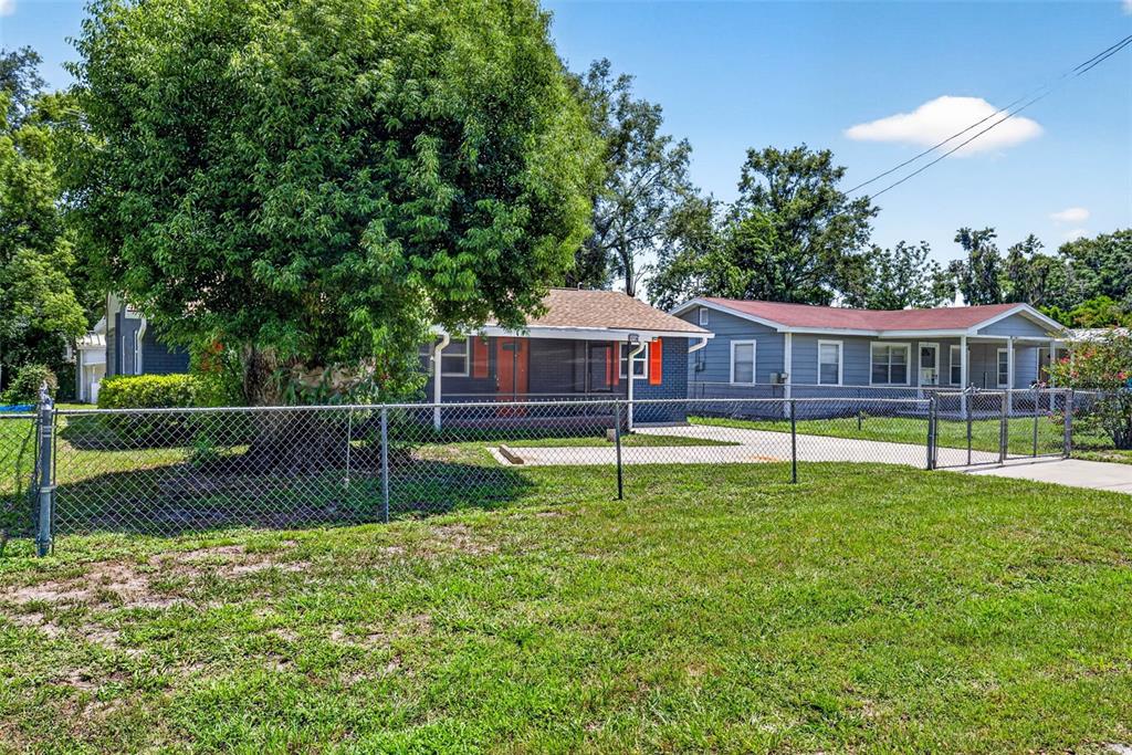 A chain-link fence encloses a yard in front of two single-story residential houses — 38706 CALVIN AVENUE, ZEPHYRHILLS, FL
