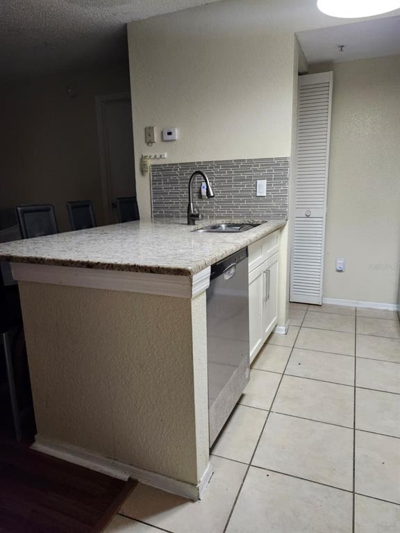 An open-concept living area with wood-look flooring, a kitchen island, and a built-in desk — 2210 GRAND CAYMAN COURT UNIT 1721, KISSIMMEE, FL
