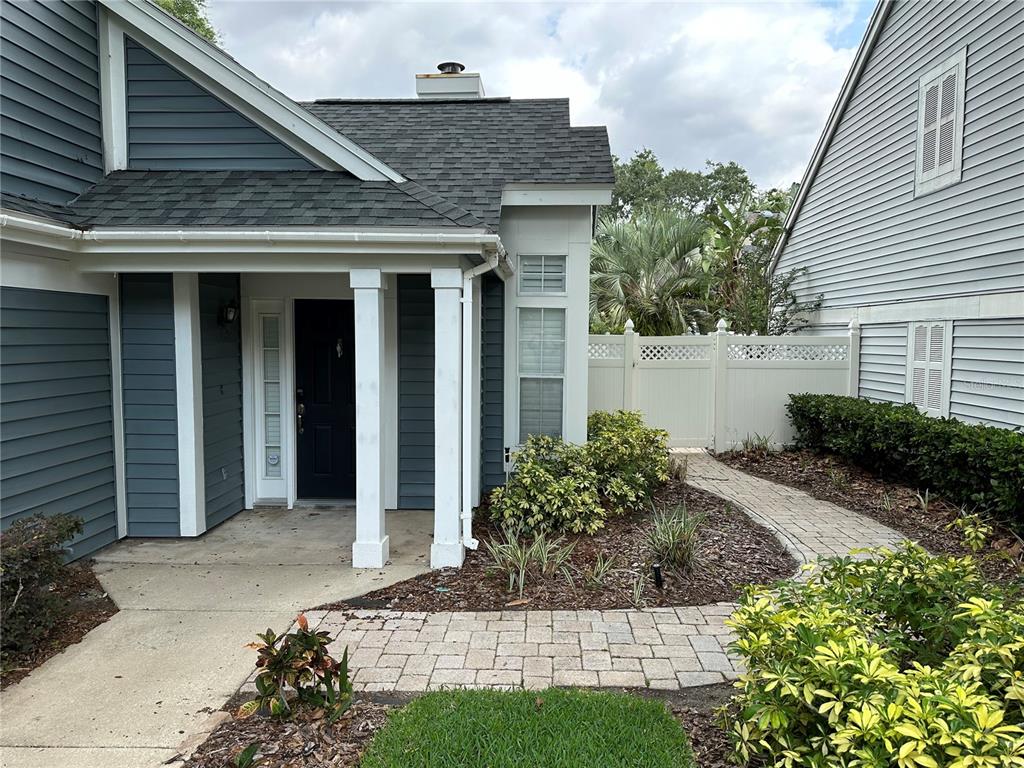 A blue-sided house features a covered front porch, white columns, and a stone walkway — 3837 HOLSTON WAY, ORLANDO, FL