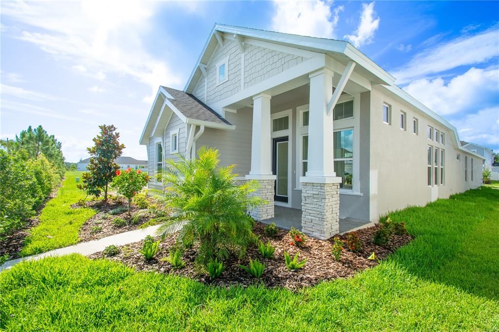 A single-story house with a covered porch, stone columns, and a landscaped front yard — 28741 JUJUBE ROAD, WESLEY CHAPEL, FL