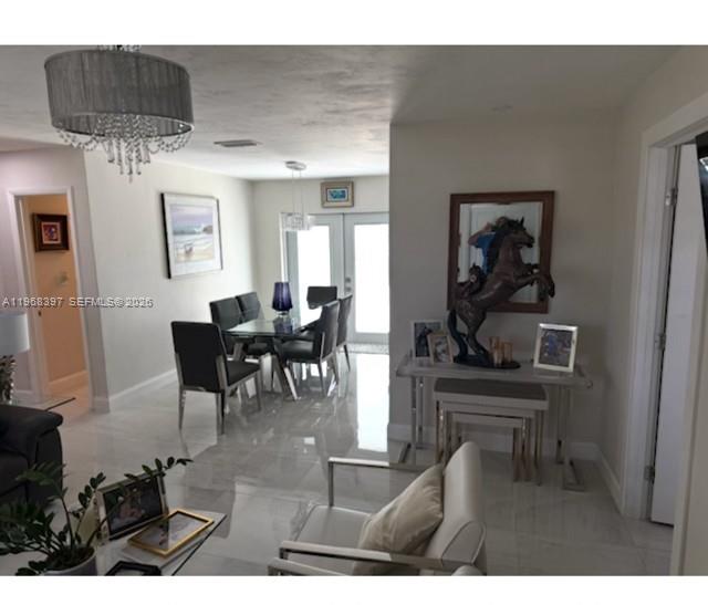 A dining area with a glass table and chairs sits adjacent to a living space — 10752 SW 141st Ln, Miami FL 33176, MIAMI, FL