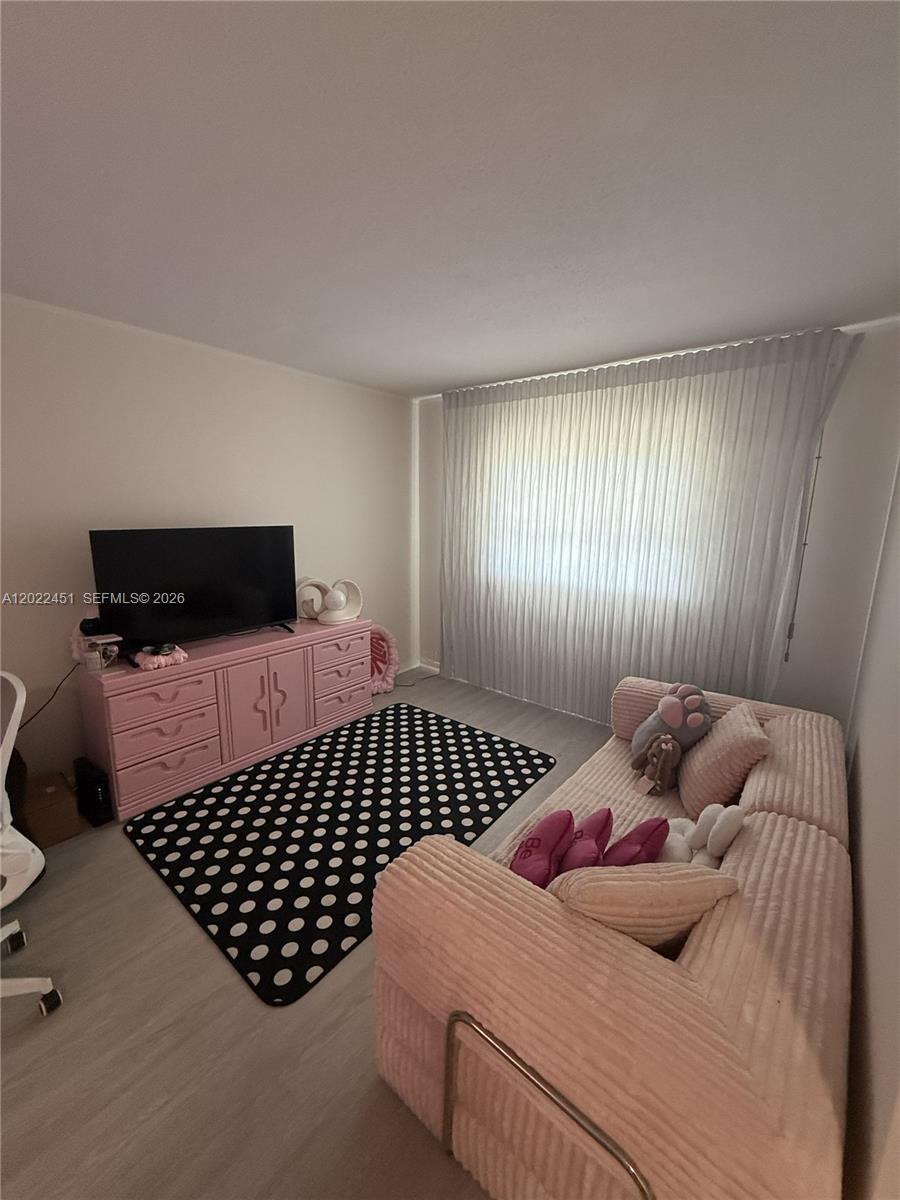 A bedroom features a pink dresser, a black polka-dot rug, and a light-colored sofa — HOLLYWOOD, FL