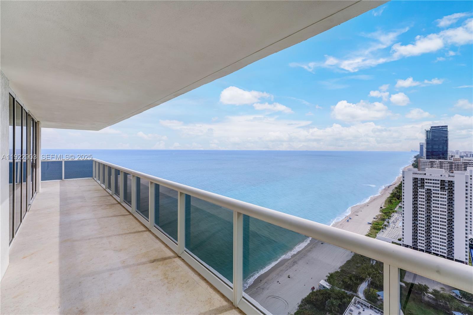 A high-rise balcony overlooks the ocean and a sandy beach with nearby buildings — 1830 S Ocean Dr # 3002, Hallandale Beach FL 33009, HALLANDALE BEACH, FL