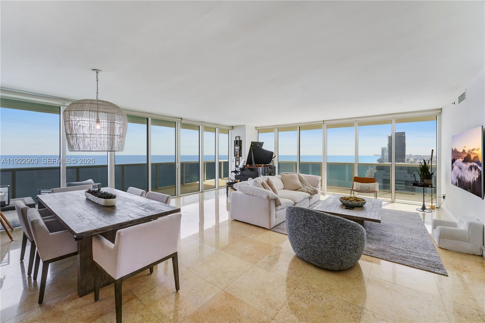 An open-concept living and dining area features floor-to-ceiling windows with ocean views and tile flooring — 1830 S Ocean Dr # 3002, Hallandale Beach FL 33009, HALLANDALE BEACH, FL