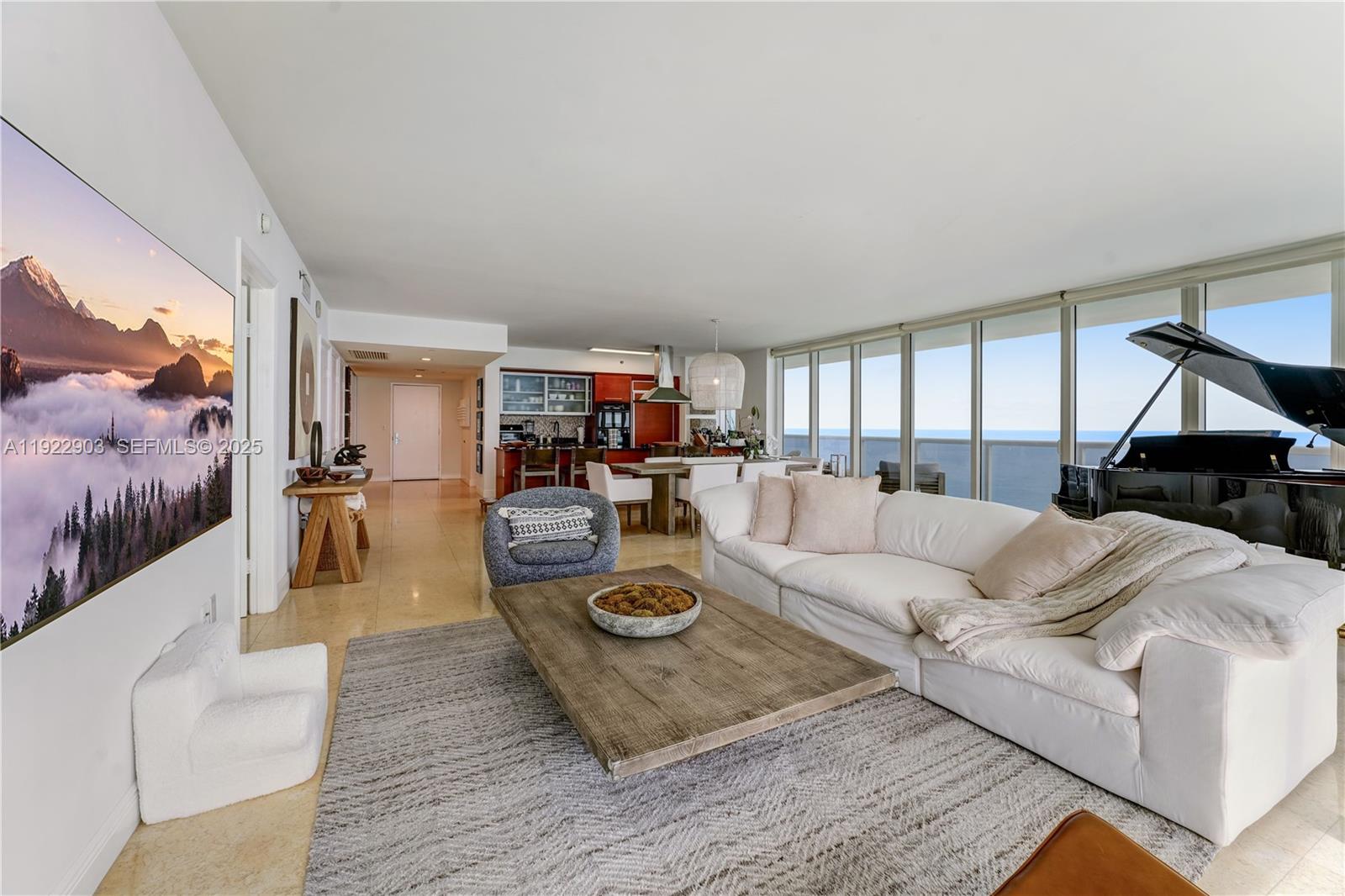 A living room features a white sofa, a grand piano, and floor-to-ceiling windows overlooking the ocean — 1830 S Ocean Dr # 3002, Hallandale Beach FL 33009, HALLANDALE BEACH, FL
