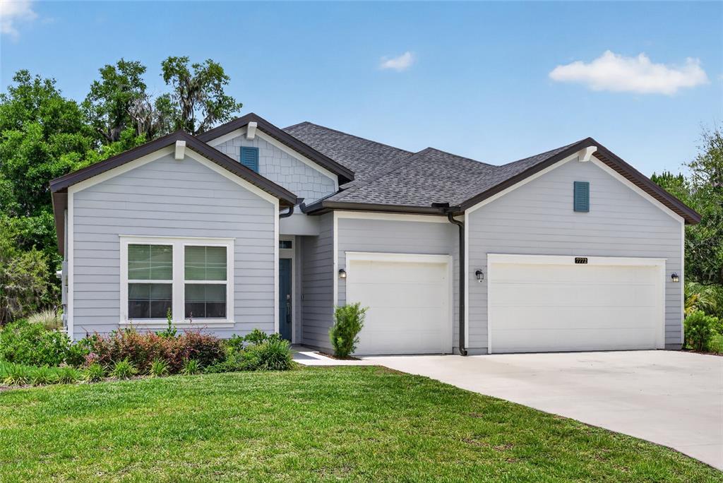 A light blue single-story house with a two-car garage and a shingled roof — 7772 SW 195TH AVENUE, DUNNELLON, FL