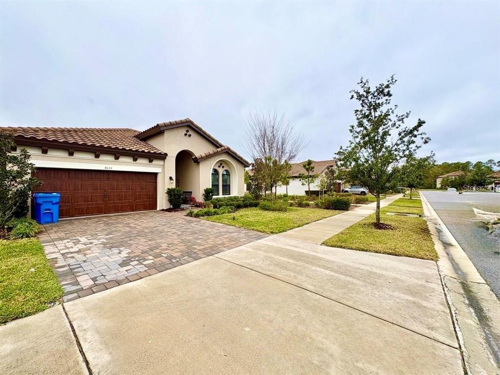 A single-story house with a brown garage door, a paved driveway, and a sidewalk — 4035 MAURICE AVENUE, ODESSA, FL