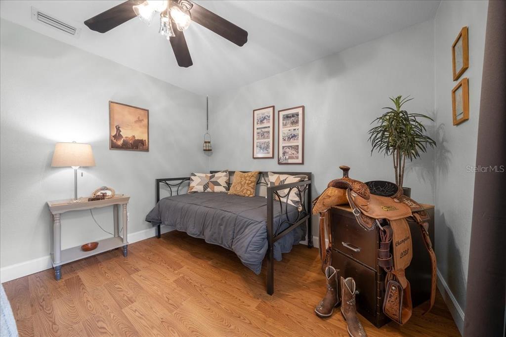 A bedroom features a daybed, a western-themed saddle display, and hardwood flooring — 530 SW 35TH STREET, OCALA, FL