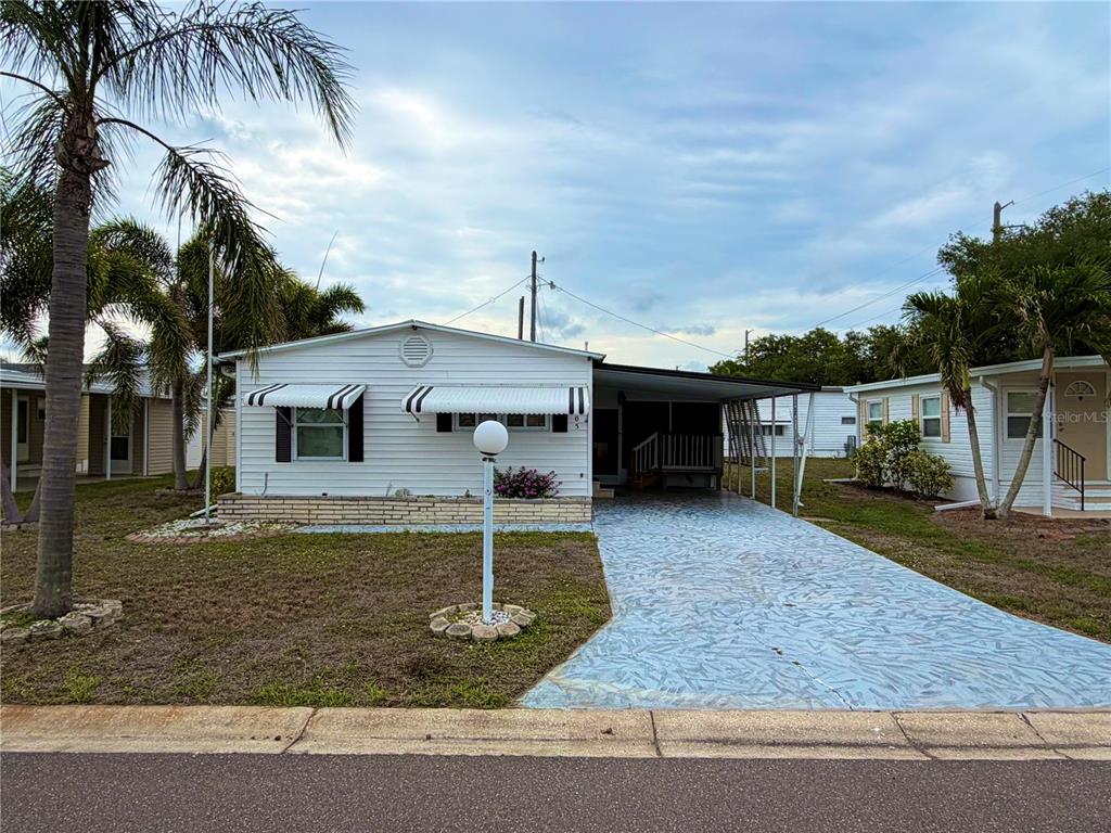 A white mobile home with a carport and a patterned concrete driveway — 5205 5TH STREET E, BRADENTON, FL