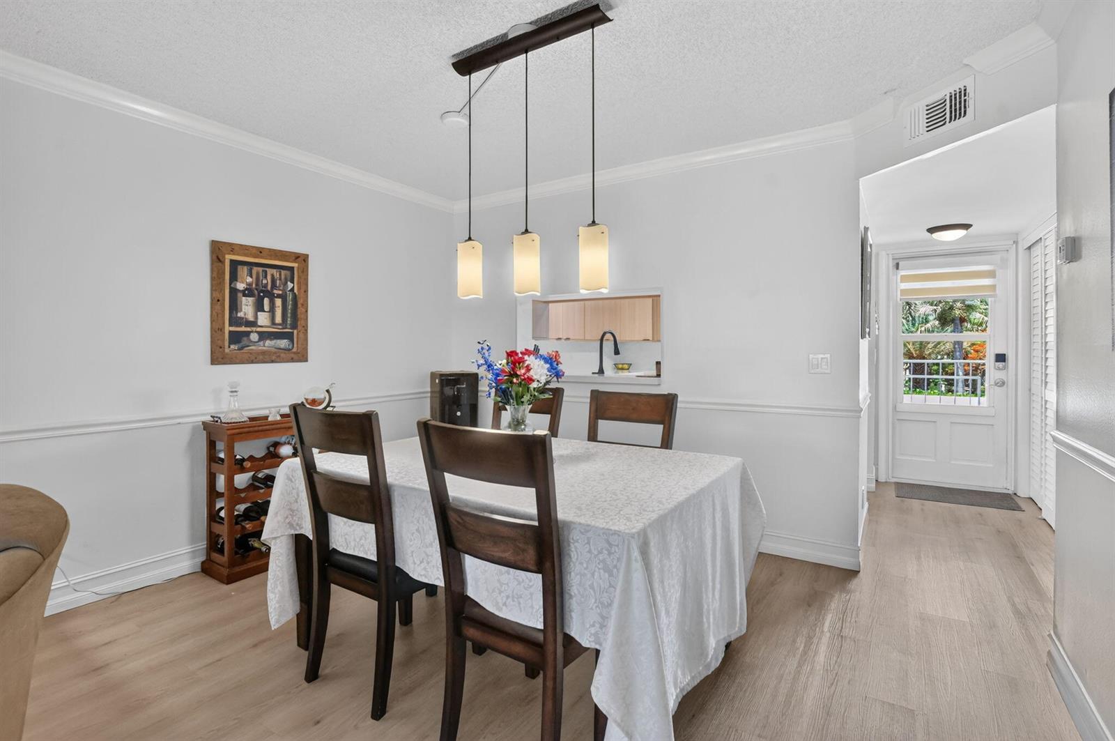 A dining room features a table with chairs, a pendant light fixture, and a pass-through window — 2809 Florida Boulevard # 208, Delray Beach FL 33483, DELRAY BEACH, FL