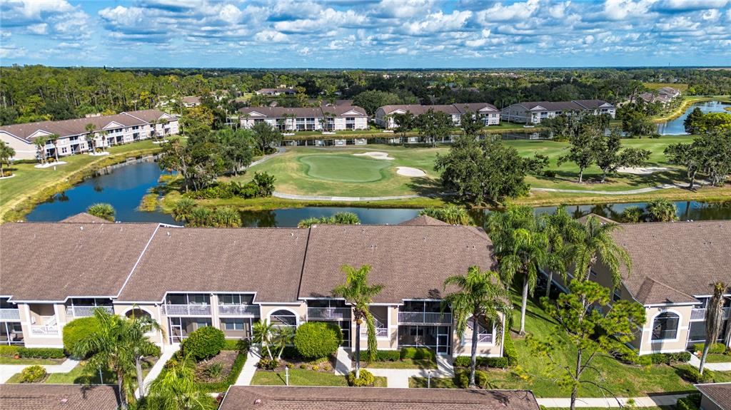 An aerial view shows multi-story apartment buildings overlooking a golf course and a pond — 5300 HYLAND HILLS AVENUE UNIT U2016, SARASOTA, FL
