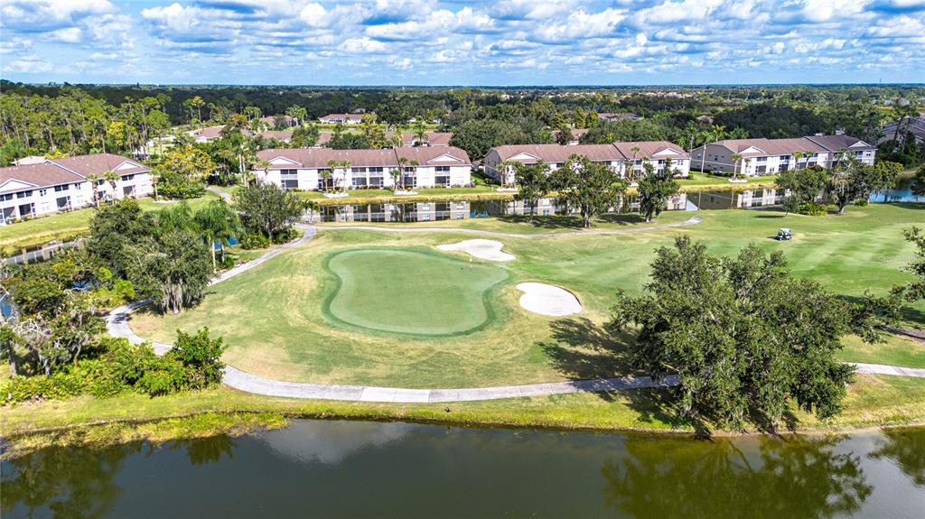 An aerial view shows a golf course green surrounded by residential buildings and a pond — 5300 HYLAND HILLS AVENUE UNIT U2016, SARASOTA, FL