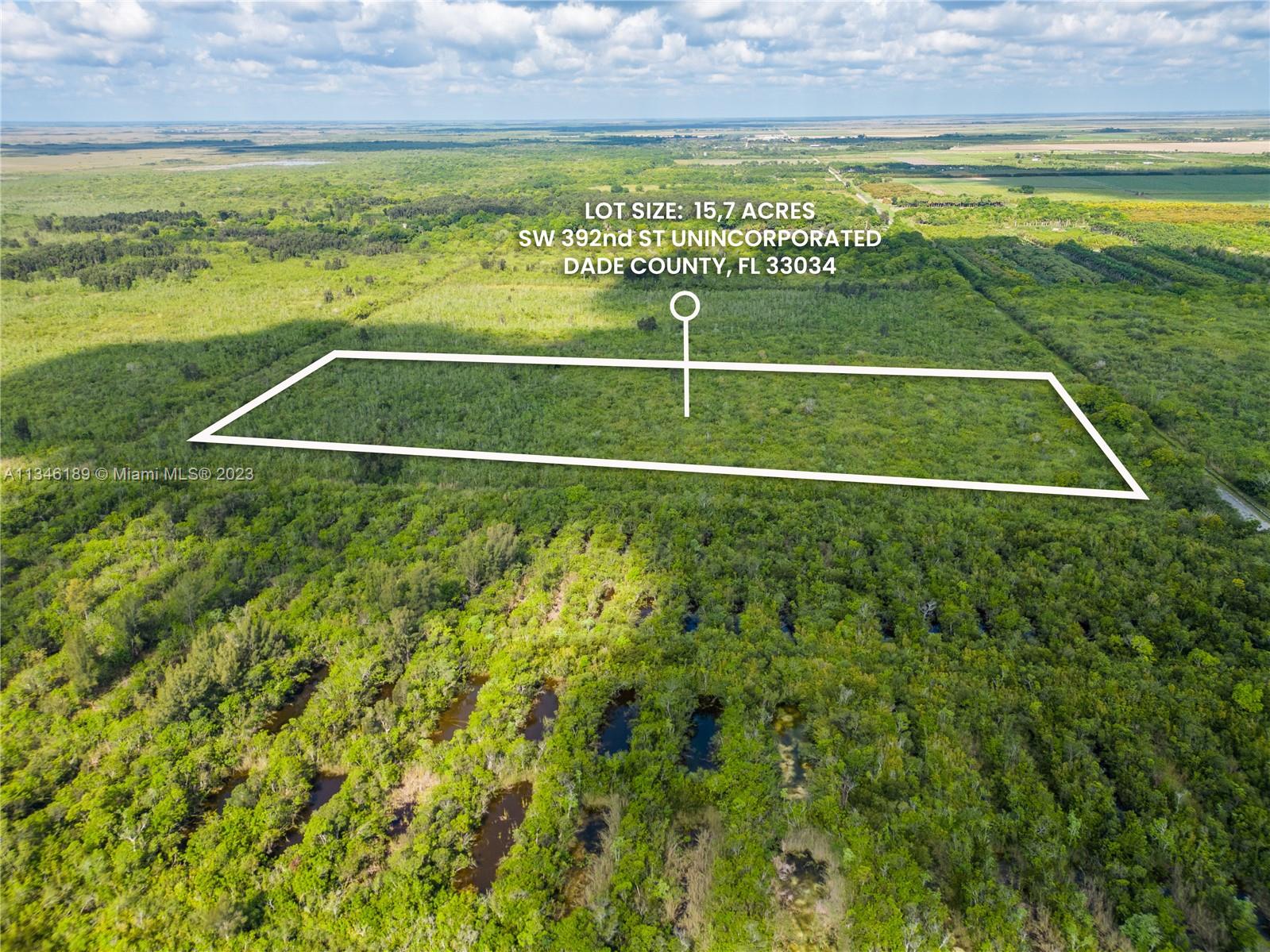 An aerial view shows a rectangular plot of land outlined in white amidst dense vegetation — SW 392nd St, Unincorporated Dade County FL 33034, UNINCORPORATED DADE COUNTY, FL