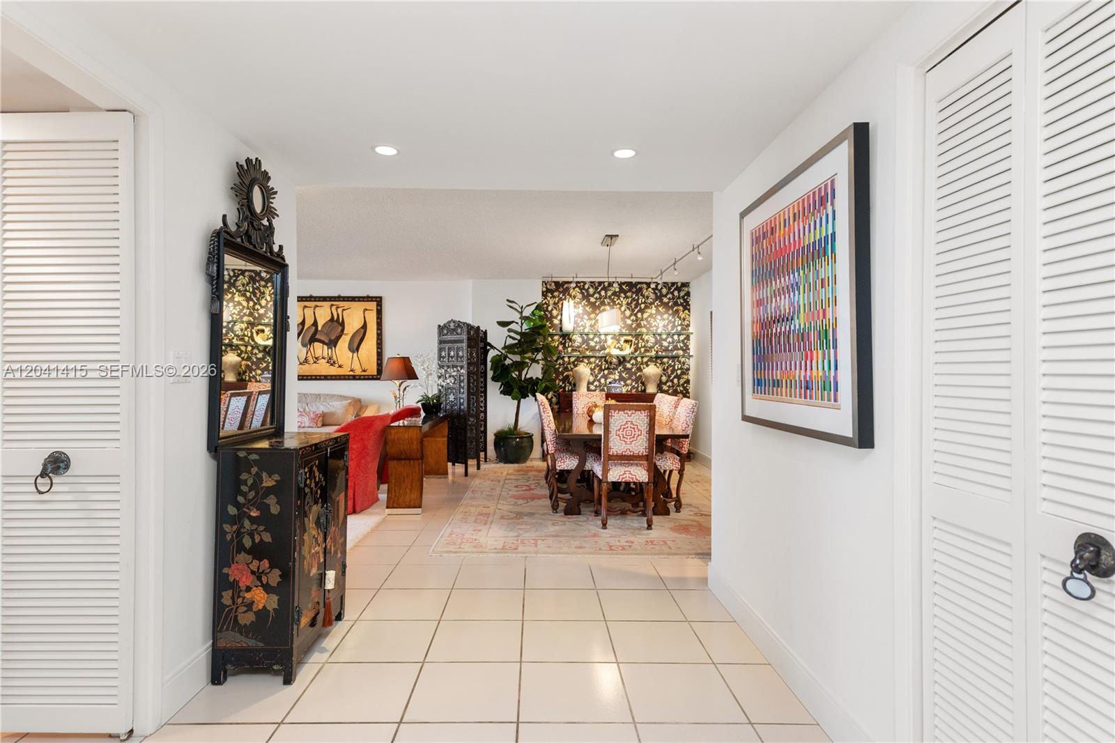 A tiled entryway leads into a dining area and living room with patterned wallpaper — 1581 Brickell Ave # 903, Miami FL 33129, MIAMI, FL