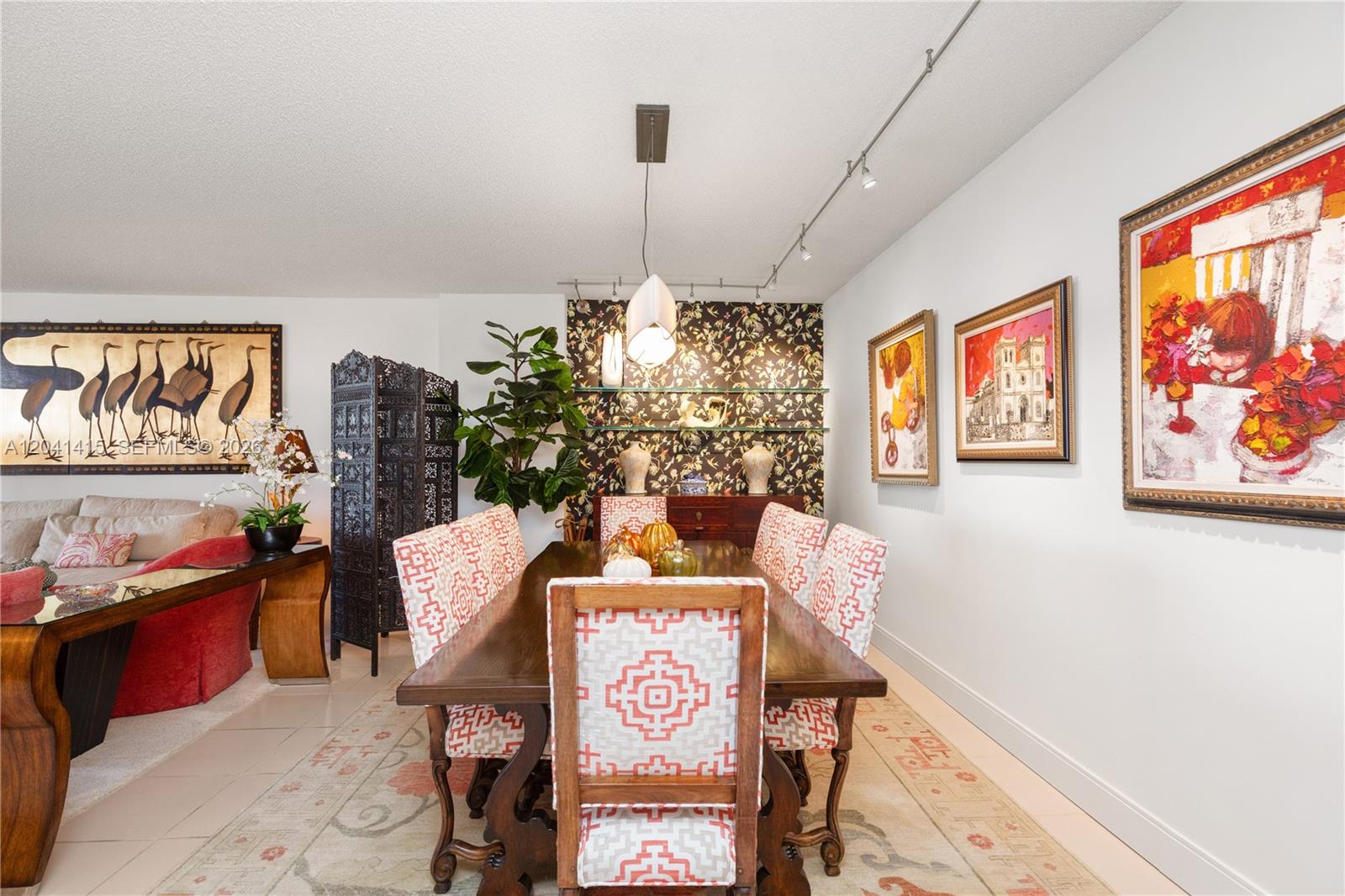 A dining room features a wooden table, patterned chairs, wallpapered accent wall, and track lighting — 1581 Brickell Ave # 903, Miami FL 33129, MIAMI, FL