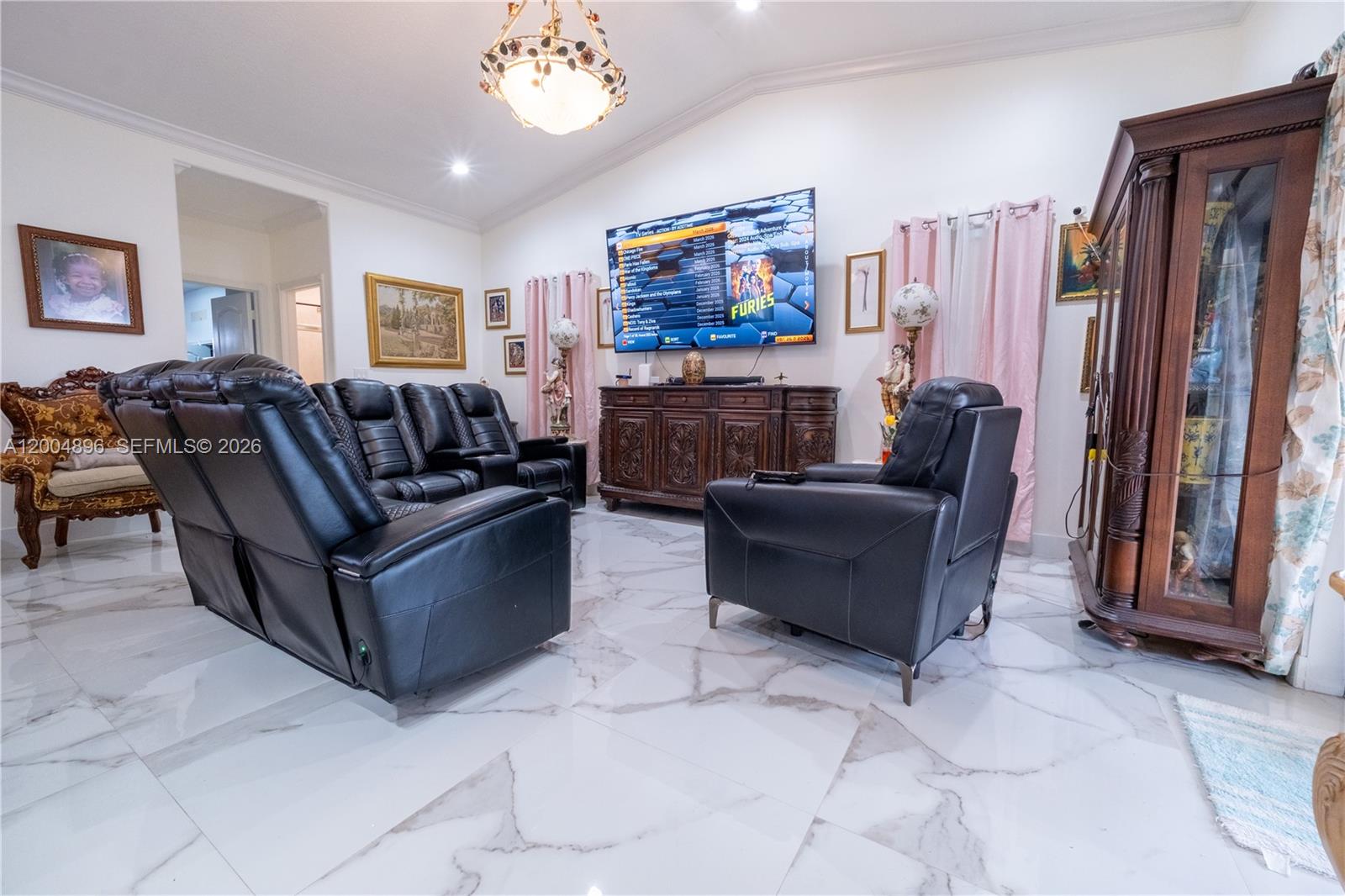 A living room features black leather recliners, a large television, and white marble-patterned tile flooring — 13911 SW 18th Ter, Miami FL 33175, MIAMI, FL