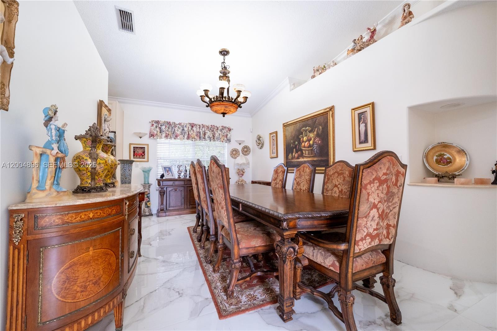 A formal dining room features a long wooden table, patterned chairs, and marble flooring — 13911 SW 18th Ter, Miami FL 33175, MIAMI, FL
