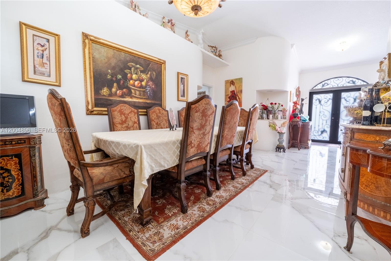 A formal dining room features a long table with patterned chairs on a patterned rug — 13911 SW 18th Ter, Miami FL 33175, MIAMI, FL