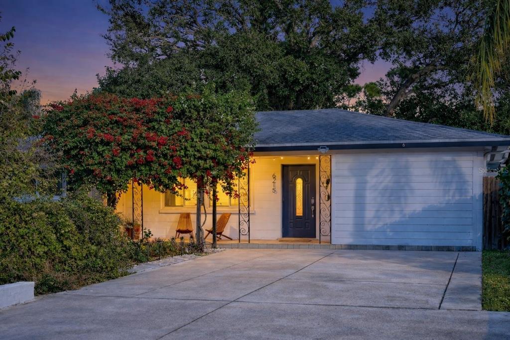 A single-story house with white siding, a dark front door, and a concrete driveway — 6215 RODGERS AVENUE, SARASOTA, FL