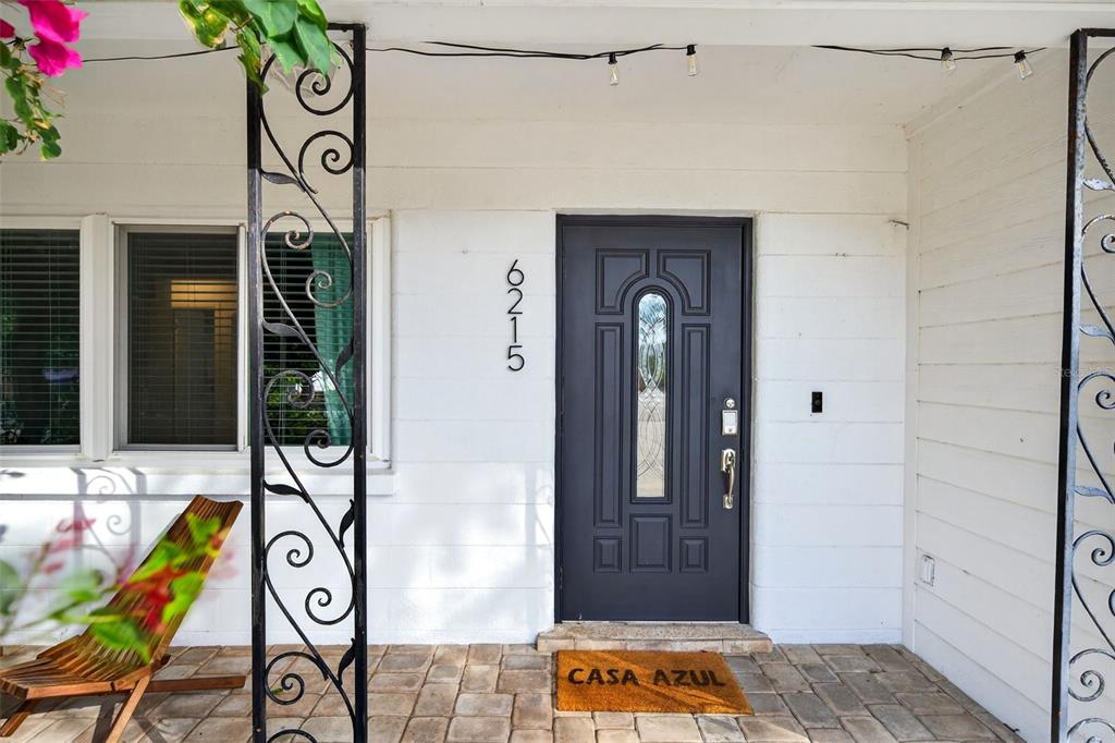 A front porch features a dark gray door, a house number, and decorative metal pillars — 6215 RODGERS AVENUE, SARASOTA, FL