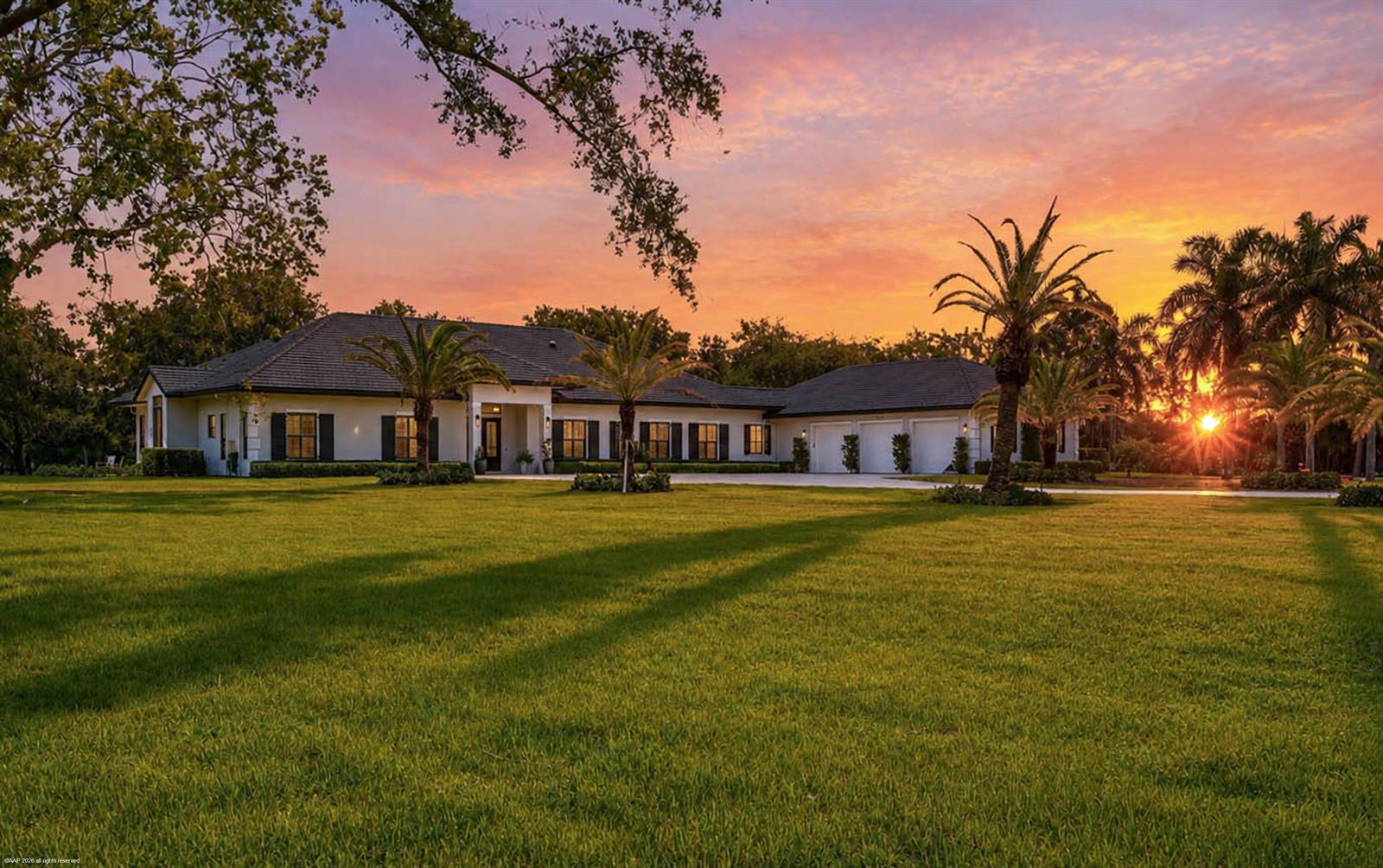 A single-story house with a dark roof and white exterior sits on a grassy lawn — 16451 Norris Road, Wellington FL 33470, WELLINGTON, FL
