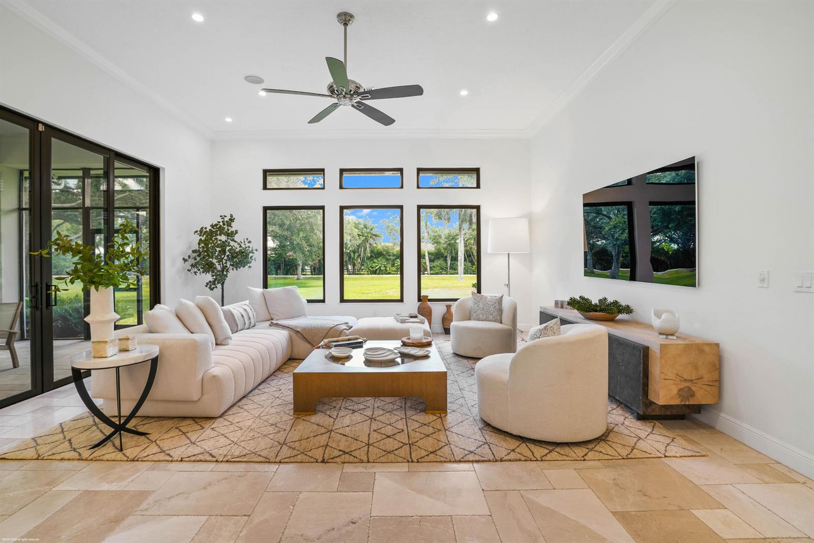 A bright living room features a large sectional, two armchairs, a coffee table, and windows — 16451 Norris Road, Wellington FL 33470, WELLINGTON, FL