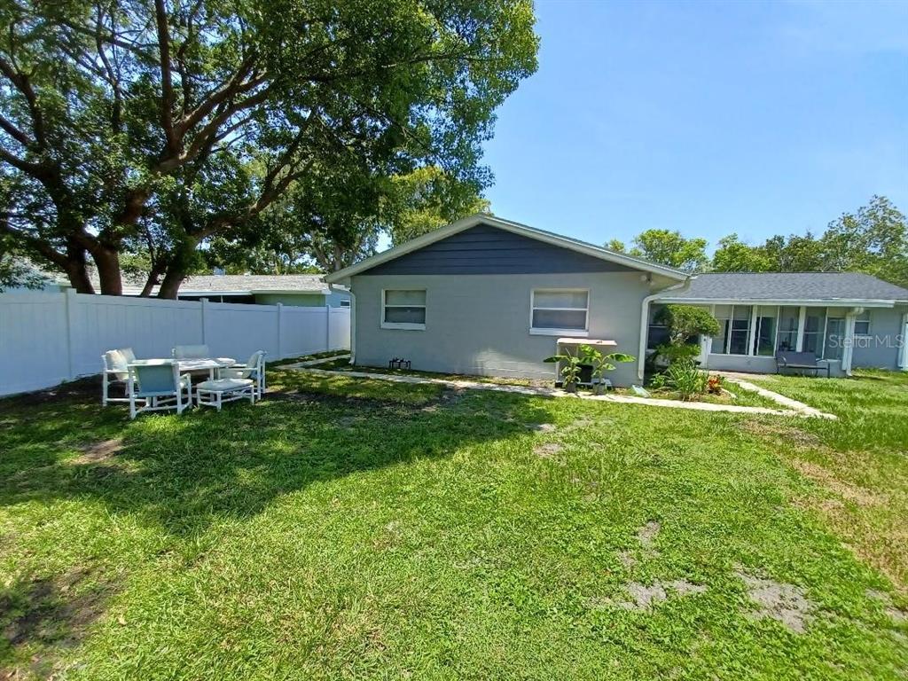 A backyard view of a gray house with a white fence and patio furniture — 1942 CONIFER COURT, WINTER PARK, FL