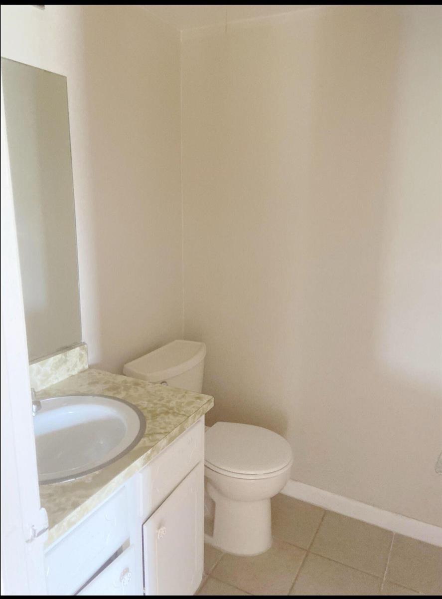 A small bathroom features a white vanity with a patterned countertop and a white toilet — 2050 Oleander Boulevard # 206, Fort Pierce FL 34950, FORT PIERCE, FL