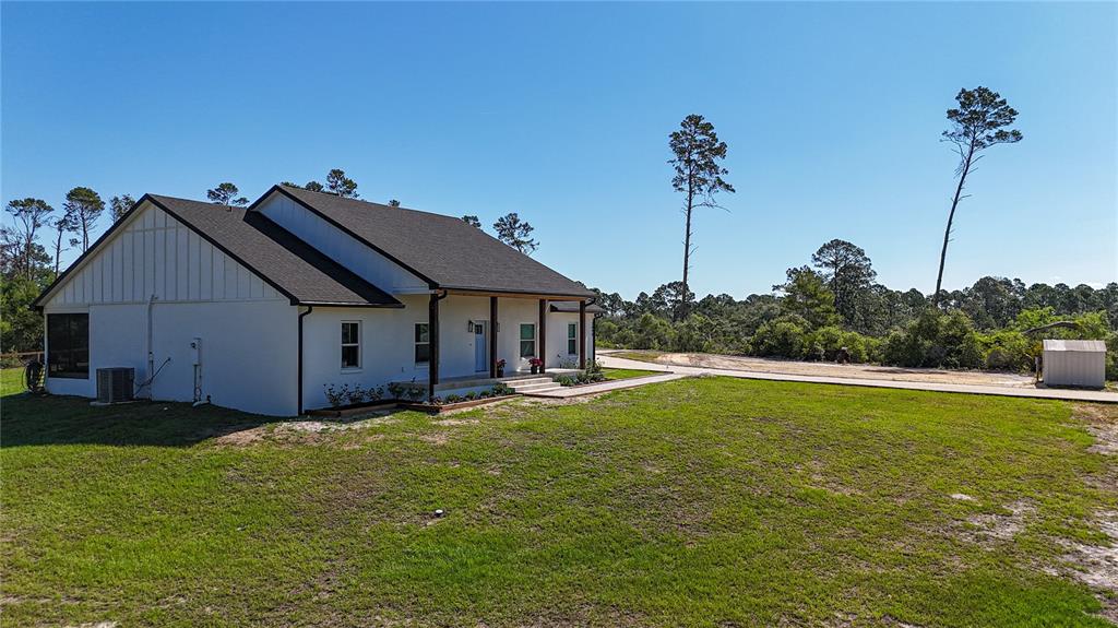 A white house with a dark roof and a front porch sits on a grassy lot — 7890 SW 129TH AVENUE, CEDAR KEY, FL