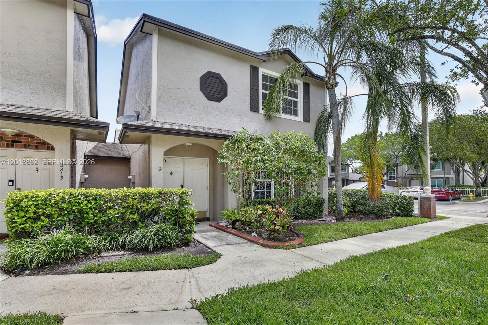A two-story townhouse with a beige stucco exterior, a palm tree, and a front walkway — 3815 NW 122nd Ter # 3815, Sunrise FL 33323, SUNRISE, FL