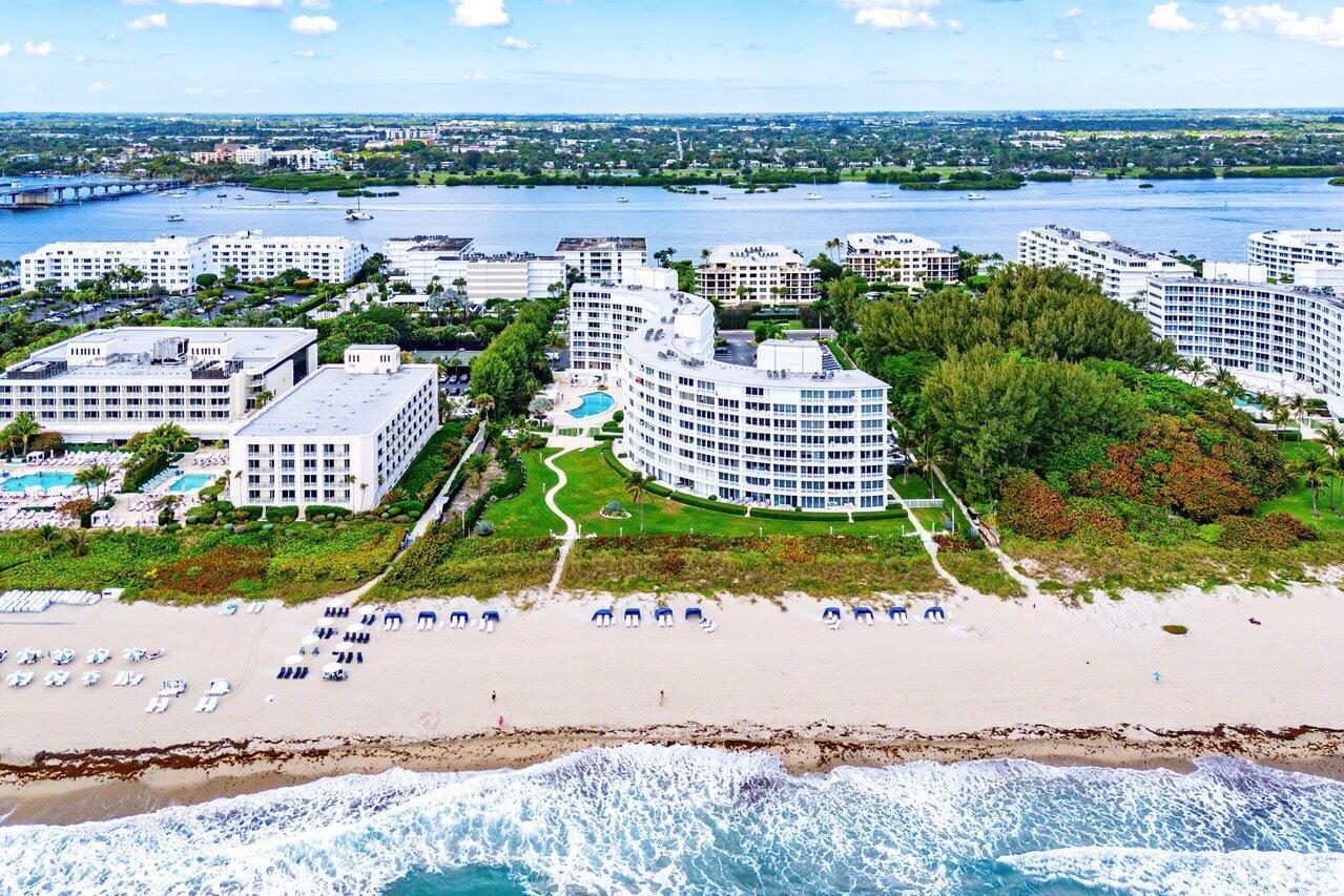 An aerial view of a beachfront resort complex with multiple white buildings and sandy shores — 2780 S Ocean Boulevard # 805, Palm Beach FL 33480, PALM BEACH, FL