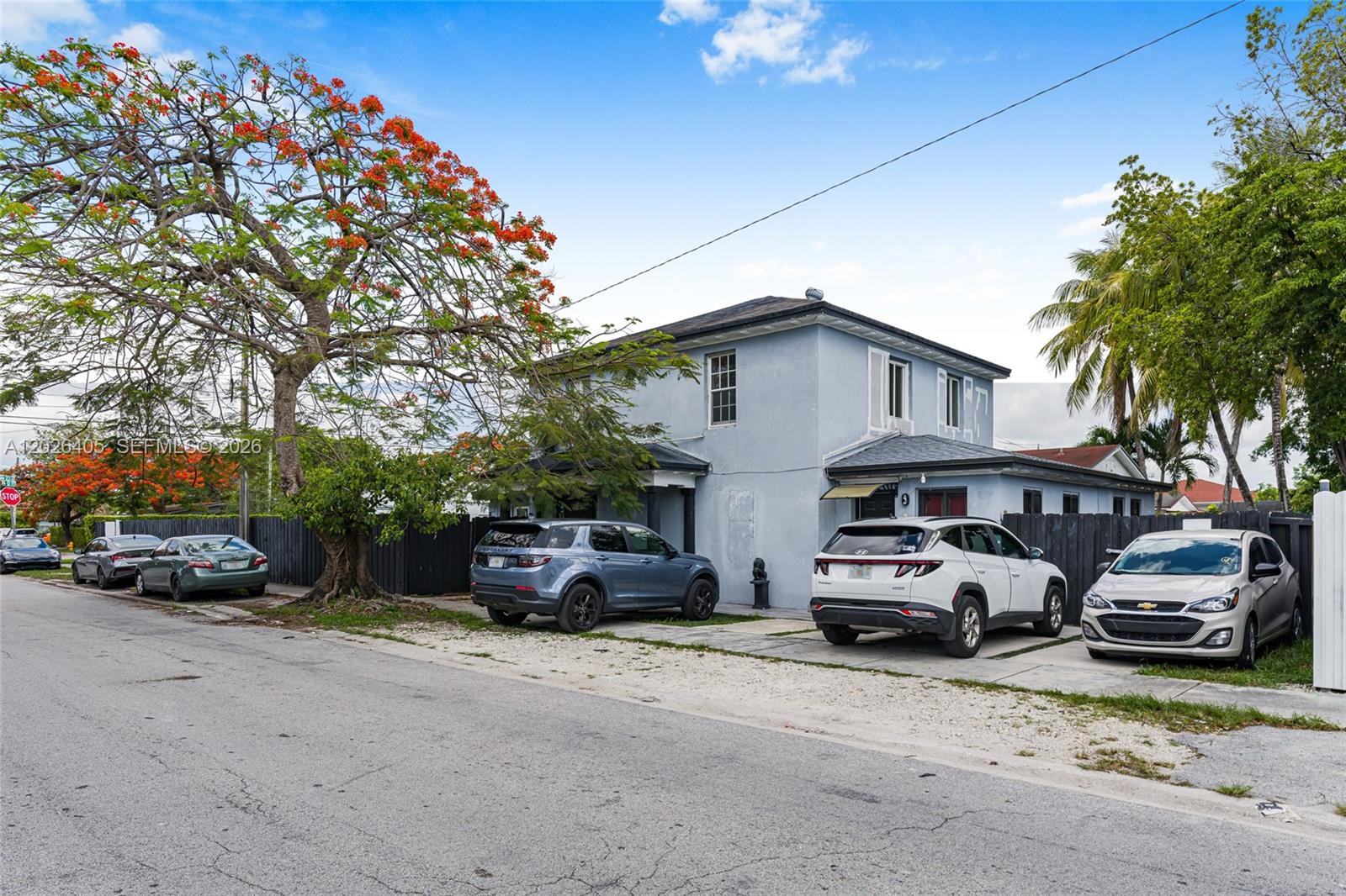 A two-story light blue house with a gravel driveway and several parked cars — 2275 NW 30th St, Miami FL 33142, MIAMI, FL