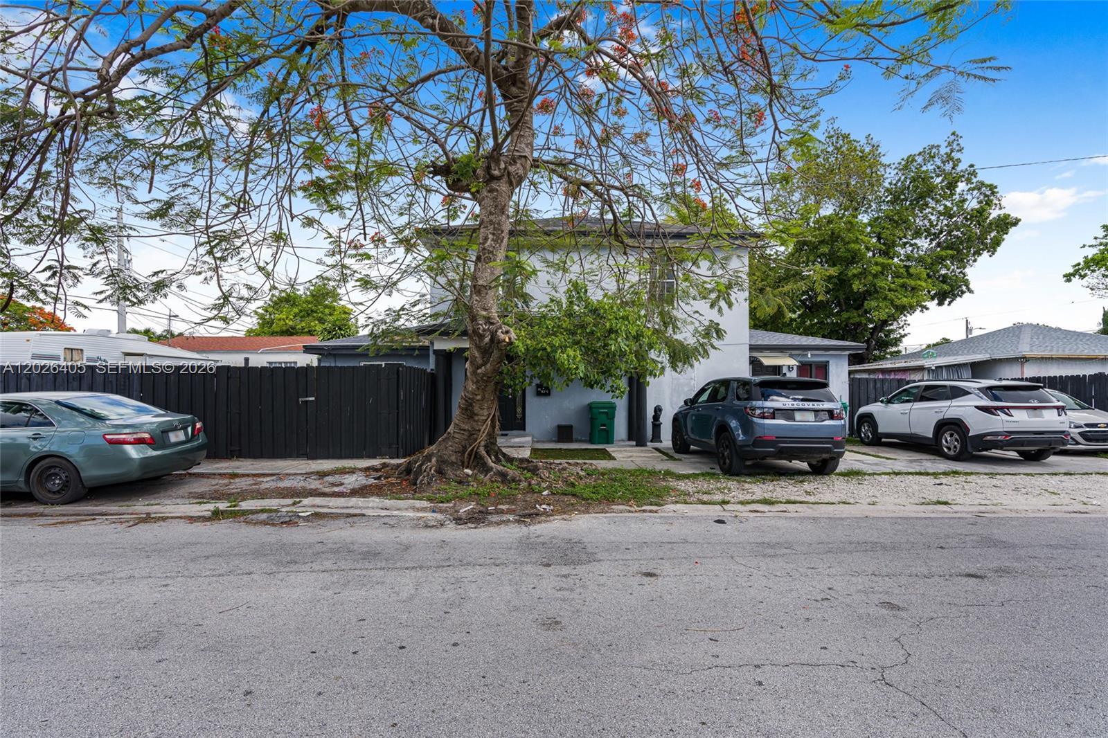 A two-story house with a large tree in the front yard and parked cars — 2275 NW 30th St, Miami FL 33142, MIAMI, FL