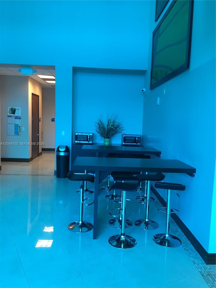 A break room features a high-top table with stools, two microwaves, and a trash can — 2300 W 84th St # 304, Hialeah FL 33016, HIALEAH, FL