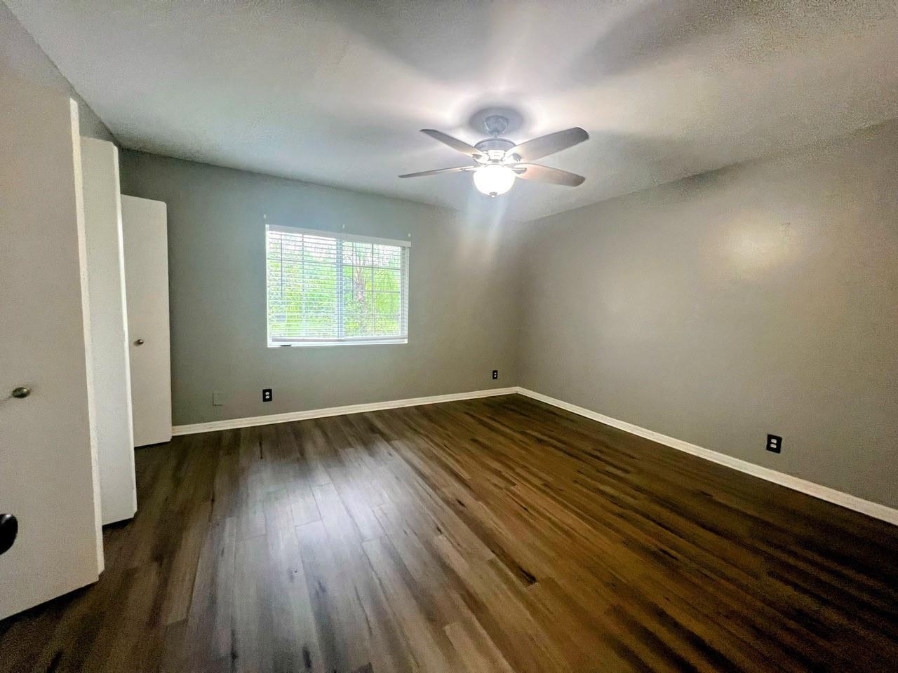 An empty bedroom features gray walls, wood-look flooring, a ceiling fan, and a window — 2253 Salerno Circle # 2253, Weston FL 33327, WESTON, FL